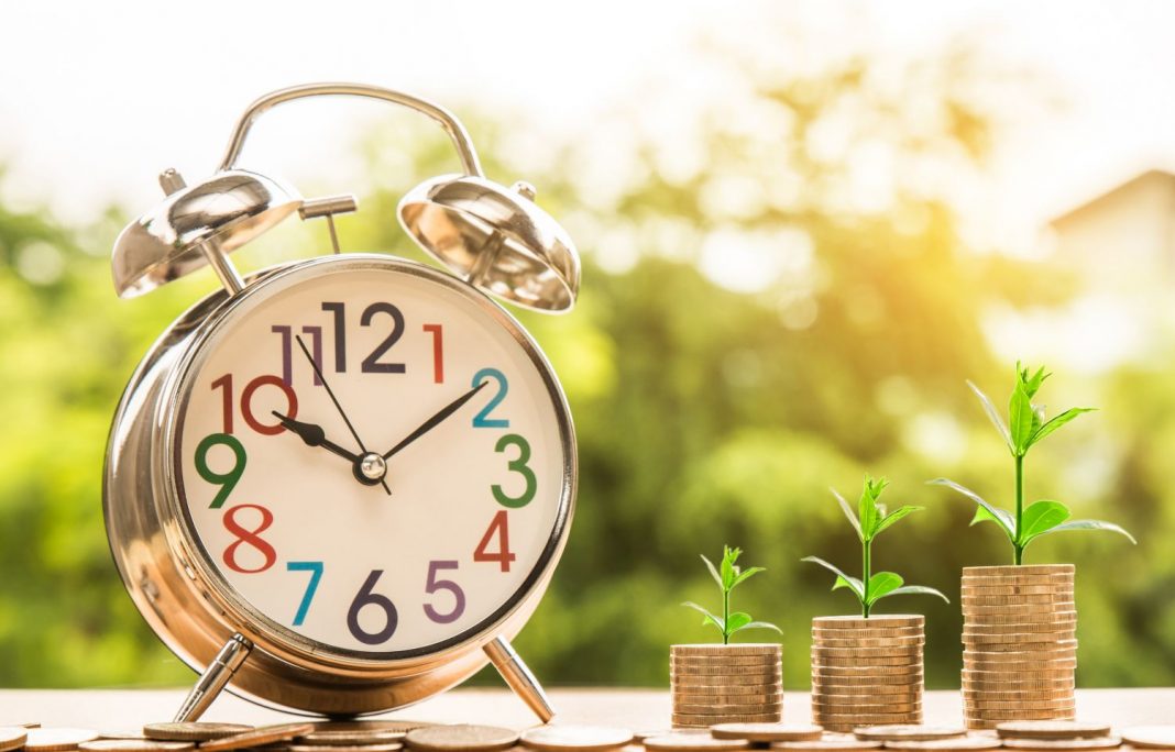 jubilación, reloj junto a monedas