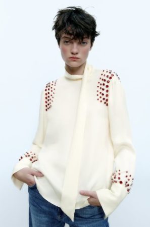 Blusa satinada con joyas