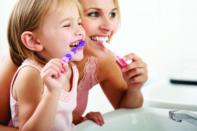 Madre e hija lavándose los dientes