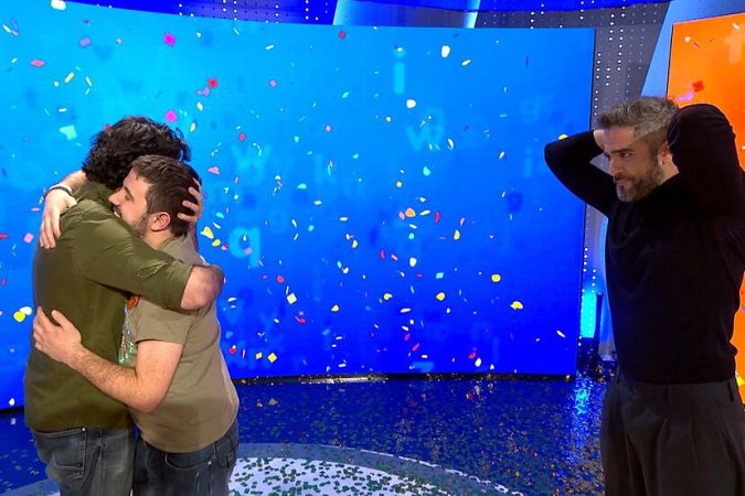 Rafa y Orestes se abrazan frente a Roberto Leal