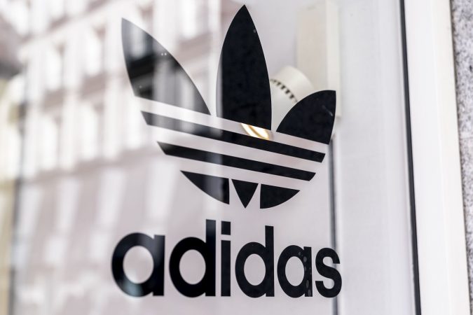 Un letrero en el escaparte de una tienda de Adidas.