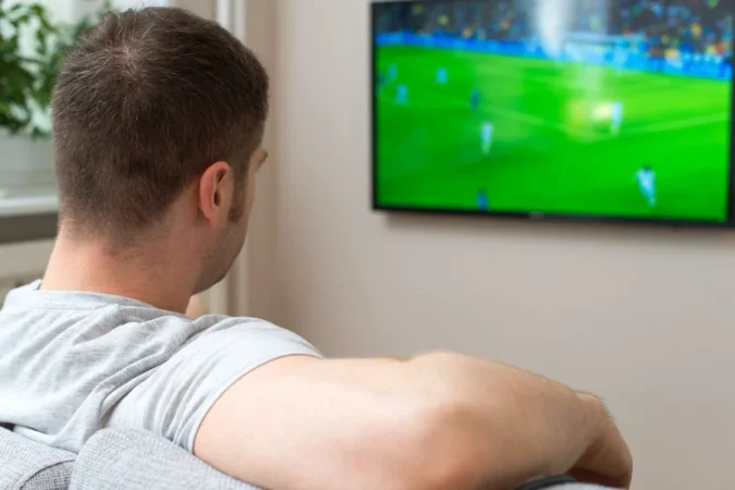 Una hombre viendo un partido de futbol por television Foto de 123RF dmitrimaruta Merca2.es