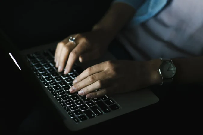 crop woman using laptop dark room Merca2.es