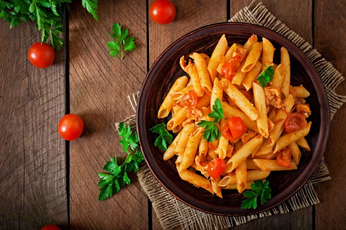 penne pasta tomato sauce with chicken tomatoes wooden table Merca2.es