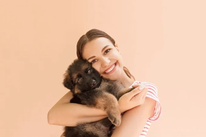 young woman enjoys hugging small cute puppy Merca2.es