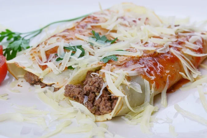 pancakes with meat tomato sauce cheese with cilantro grated cheese top Merca2.es