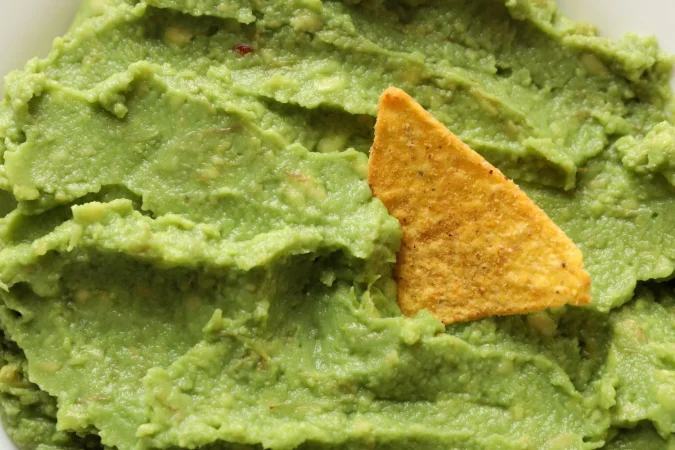 tasty fresh guacamole chip close up Merca2.es