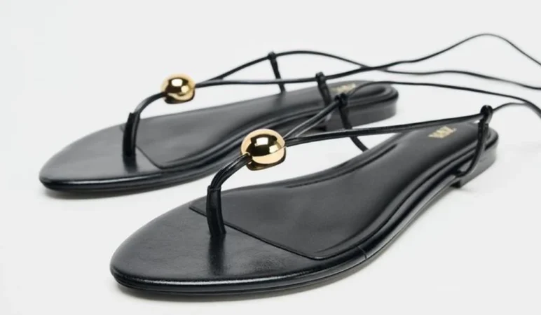 1. Sandalias planas de tiras con aplique dorado – 25,95€