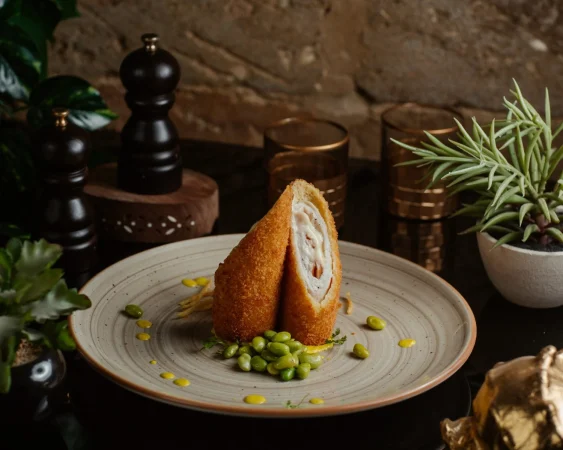 asado con galletas saladas rollos de pechuga de pollo servidos con judias verdes Merca2.es