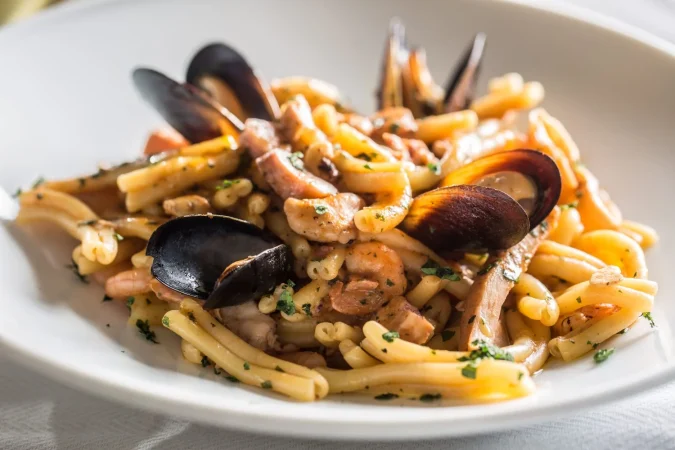 pasta italiana con mejillones y gambas en plato blanco Merca2.es