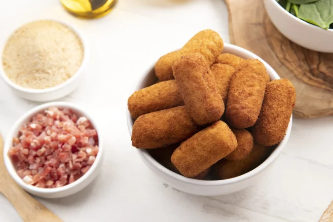 comida que contiene croquetas con tocino y espinacas Merca2.es