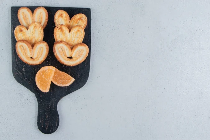 galletas escamosas y mermeladas en una pizarra sobre fondo de marmol Merca2.es