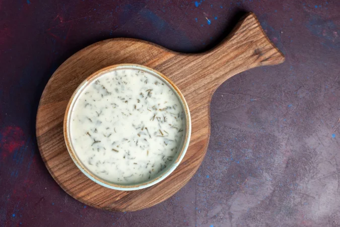 vista superior sabrosa dovga de yogur con verduras dentro de la mesa oscura Merca2.es