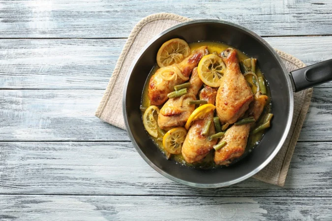 Cómo hacer un inigualable pollo al chilindrón digno de tu abuela 20 Merca2.es deliciosos muslos de pollo con limon en sarten sobre mesa de madera Merca2.es