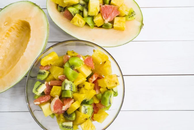 melon la mitad con rodajas de frutas en un tazon Merca2.es