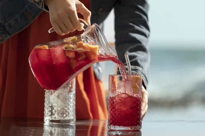 vista lateral adulto vertiendo bebida de sangria Merca2.es