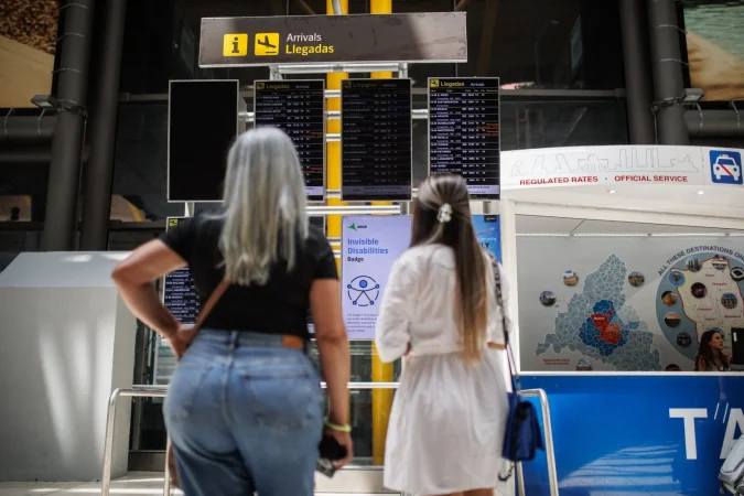 Dos pasajeras observan un panel de llegadas en la Terminal T4 del Aeropuerto Adolfo Suárez-Madrid Barajas. Fuente: Agencias.