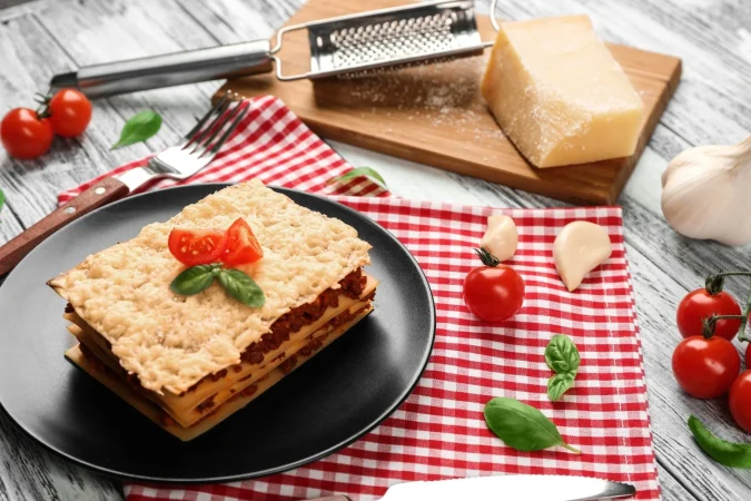 lasagna de carne casera en una mesa de madera blanca Merca2.es