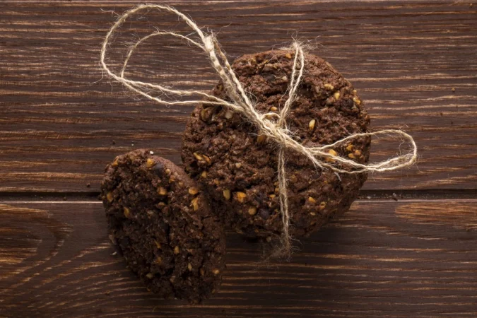 vista superior de galletas de chispas de chocolate con cereales nueces y cacao atados con una cuerda en madera Merca2.es