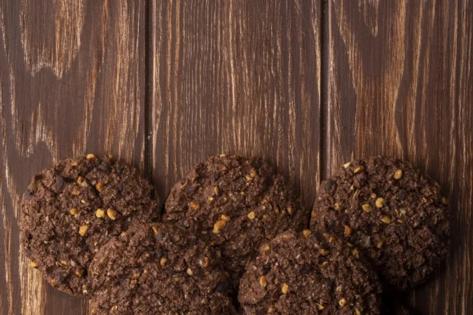 vista superior de galletas de chispas de chocolate con cereales nueces y cacao en madera Merca2.es