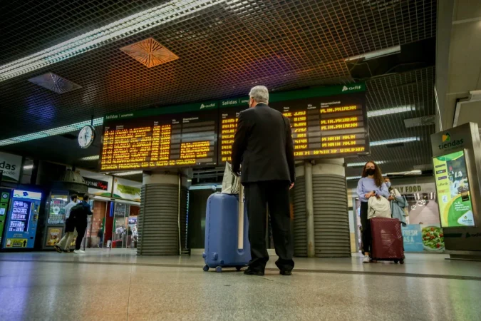 Renfe acumula 19 minutos de retraso medio en verano y casi 1.000 trenes llegan más de una hora tarde 1 Merca2.es Un hombre camina con su equipaje en la estación de Madrid-Puerta de Atocha, 7 de octubre de 2021, en Madrid (España). Fuente: Agencias