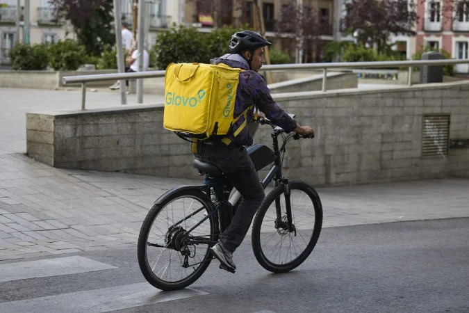 Un repartidor de Glovo en bicicleta por una calle de Madrid, 29 de agosto de 2025, en Madrid (España). Fuente: Agencias