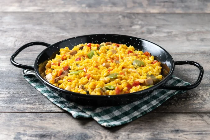 arroz amarillo con pollo y verduras en una mesa de madera 2 Merca2.es