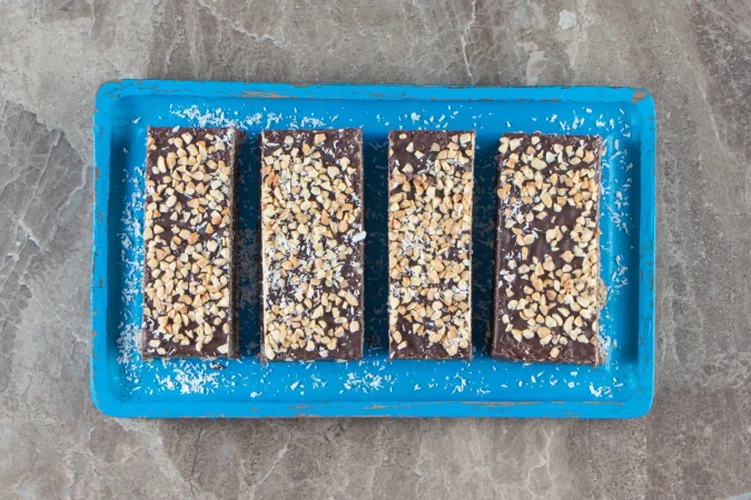 Barritas energéticas caseras: la receta fácil que te dará energía todo el día 1 Merca2.es barra de chocolate en rodajas con nueces sobre placa de madera sobre marmol Merca2.es