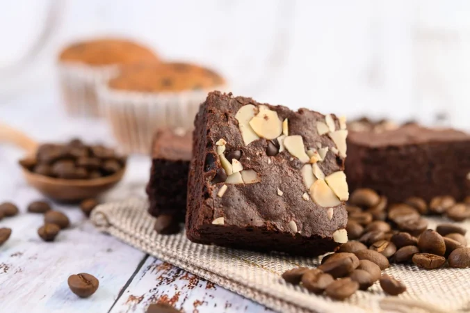 brownie de chocolate en cilicio y granos de cafe sobre una mesa de madera 1 Merca2.es