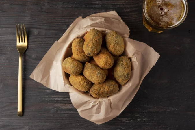 comida que contiene croquetas y un vaso de cerveza Merca2.es