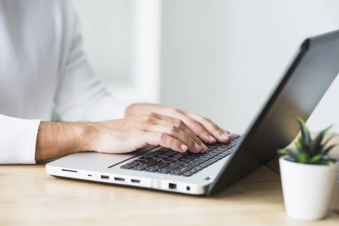 primer plano de la mano de un hombre de negocios trabajando en la computadora portatil Merca2.es