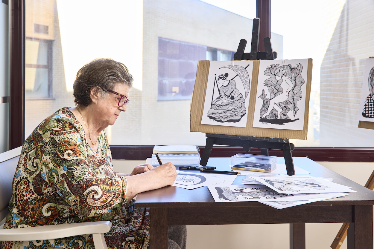 Una persona mayor participa en una actividad de pintura en un centro Bouco 2 Merca2.es