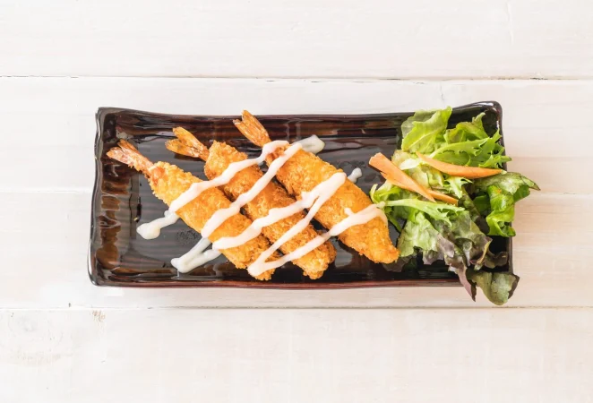 Langostinos rebozados en tempura, el crujido más delicado del mar 2 Merca2.es gambas fritas sobre madera 1 Merca2.es
