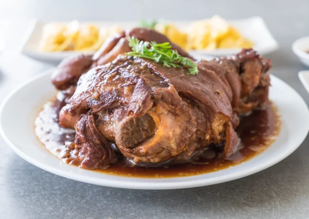 Codillo de cerdo al horno, el asado lento que conquista por dentro 1 Merca2.es pierna de cerdo estofado en sopa de salsa Merca2.es