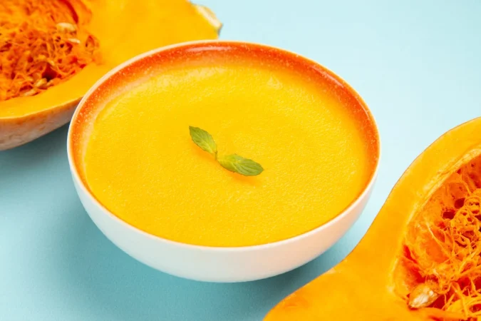Crema de zanahorias y calabaza, la dulzura cálida que reconforta desde dentro 1 Merca2.es vista frontal de la sopa de calabaza con calabazas frescas en la sopa de color de plato de mesa azul Merca2.es