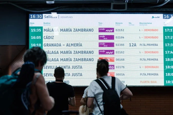 Varias personas observan una pantalla informativa en la Estación de Madrid - Puerta de Atocha - Almudena Grandes a cargo de ADIF, a 30 de agosto de 2025, en Madrid (España). Fuente: Europa Press