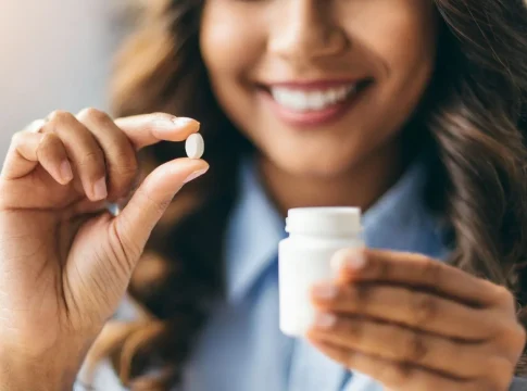 las-manos-de-las-mujeres-extraen-delicadamente-una-pildora-de-una-botella-que-refleja-las-opciones-de-salud-y-bienestar