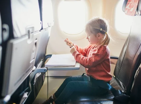 viaje en avión Una niña se entretiene dibujando en un avión