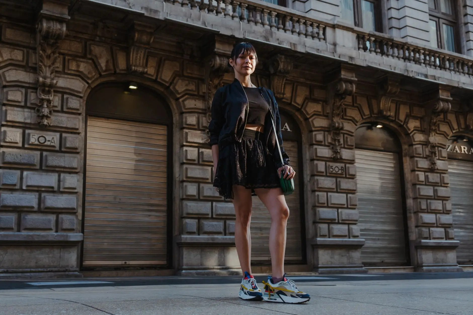 Una mujer con estilo posa con confianza en una calle de la ciudad, mostrando moda urbana chic.