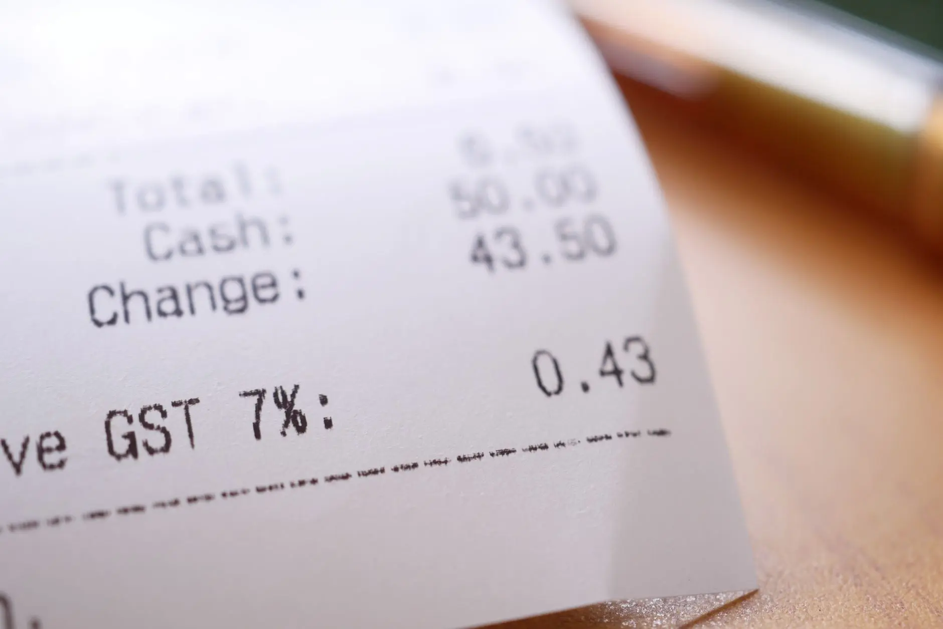 Imagen detallada en primer plano de un recibo de compras mostrando GST y cambios totales.