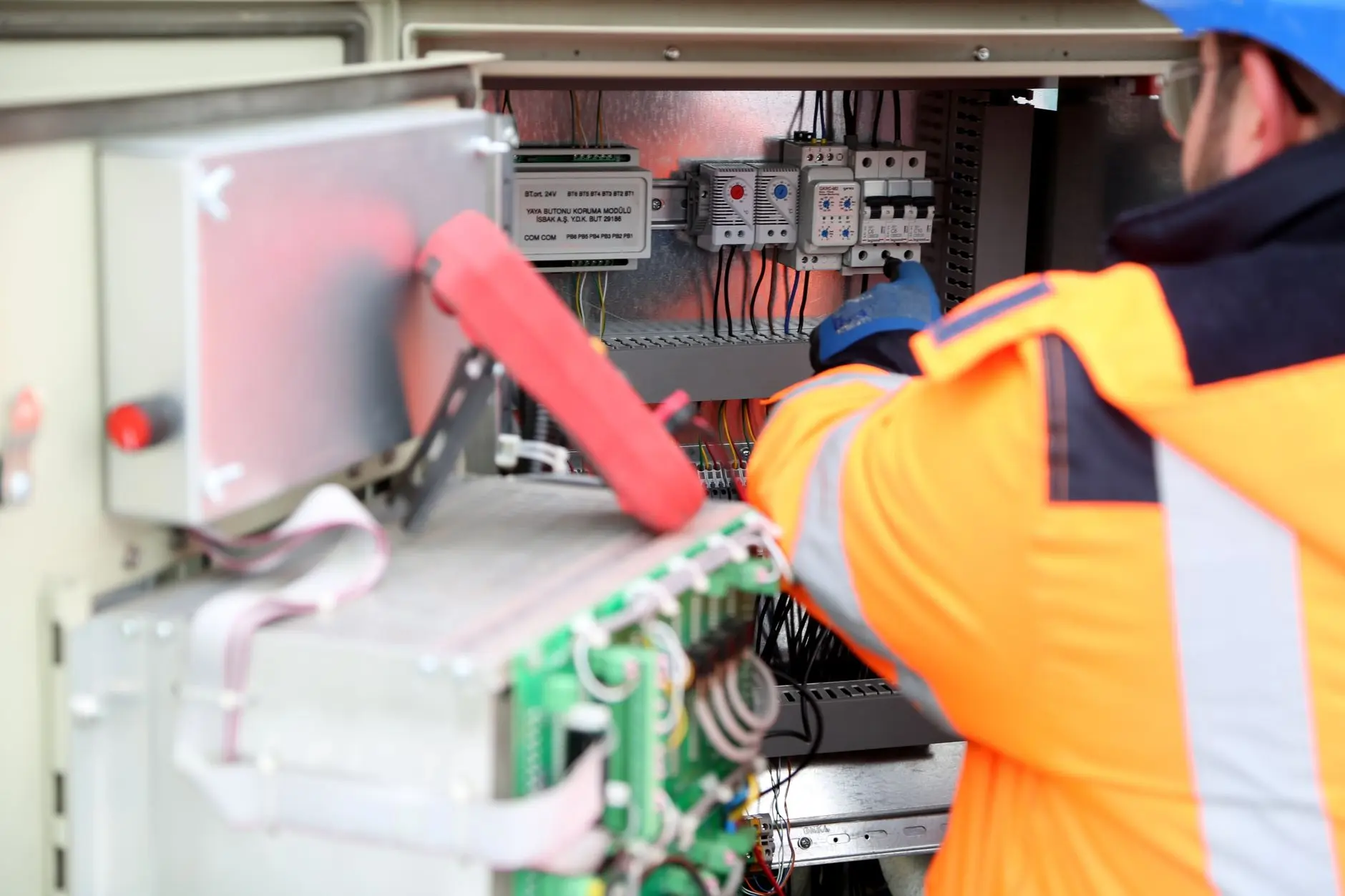 Ingeniero profesional inspeccionando la placa de circuito eléctrico industrial, asegurando los estándares de seguridad.