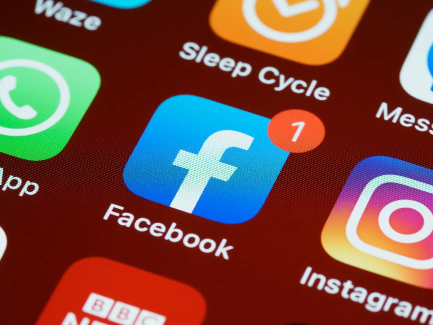 Un primer plano detallado de los íconos de aplicaciones de redes sociales en la pantalla de un smartphone.