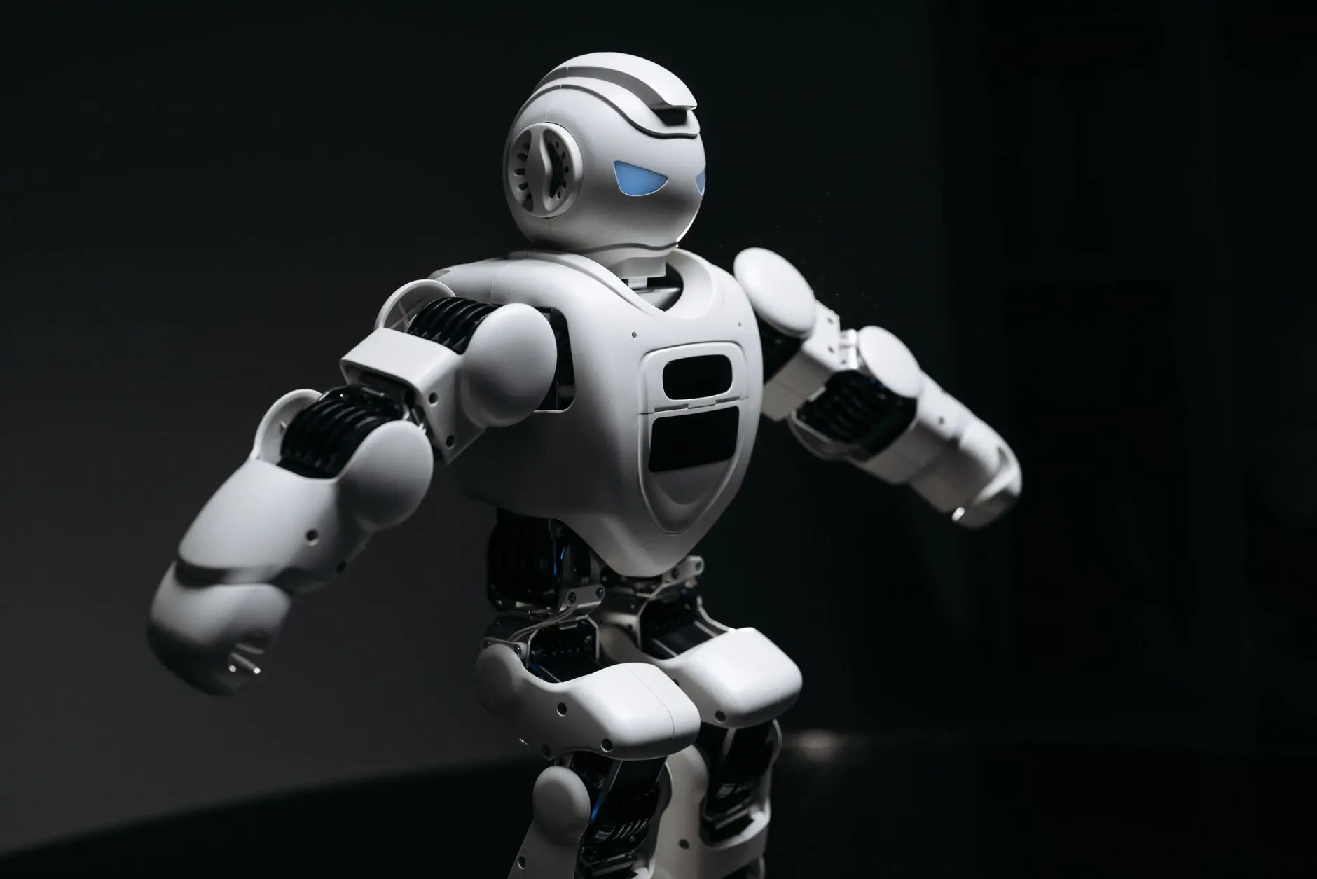 Primer plano de un robot humanoide futurista bajo una iluminación dramática en una atmósfera oscura.