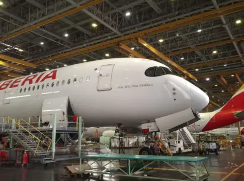 Airbus A350 de Iberia dentro de un hangar Avión Airbus A350 de Iberia dentro de un hangar, rodeado de equipos.
