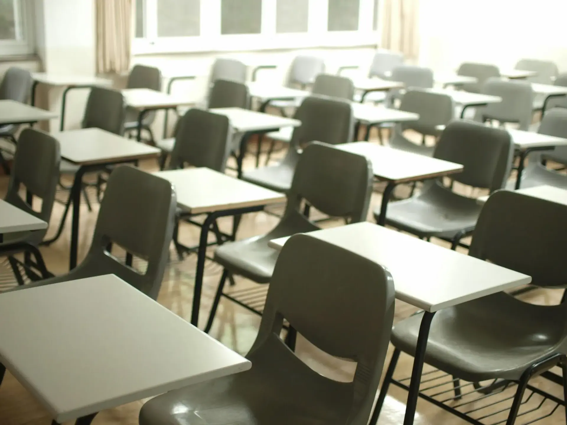 Aula vacía con mesas y sillas oposiciones docentes 2027