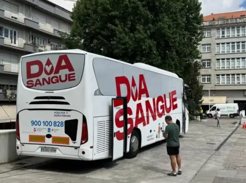 Autobús de donación de sangre estacionado Autobús de donación de sangre estacionado junto a edificios, con una persona en el exterior