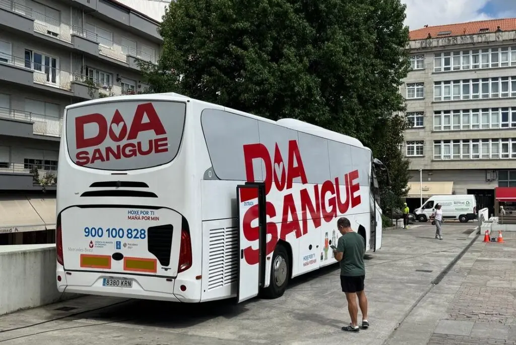Autobús móvil para donar sangre Autobús móvil de donación de sangre estacionado con una persona junto a la puerta.