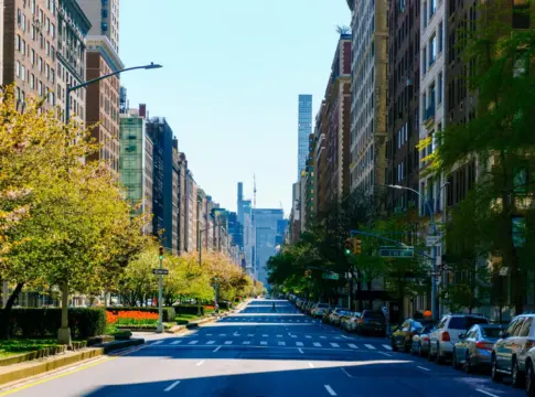 Avenida arbolada con edificios y coches Consumo retira anuncios turísticos