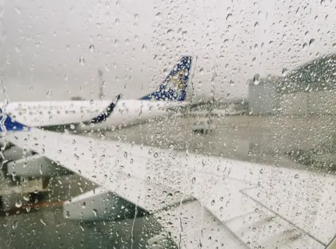 Avión bajo la lluvia visto desde una ventana aeropuertos regionales España