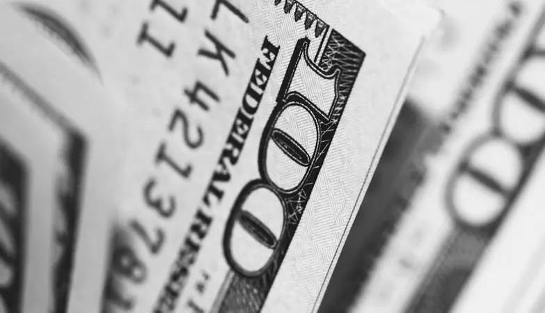 La Reserva Federal afronta su reunión más abierta: el mercado apuesta por una pausa, pero los expertos advierten de una posible sorpresa 3 Merca2 Primer plano en blanco y negro de un billete estadounidense de cien dólares. Fuente: Agencias